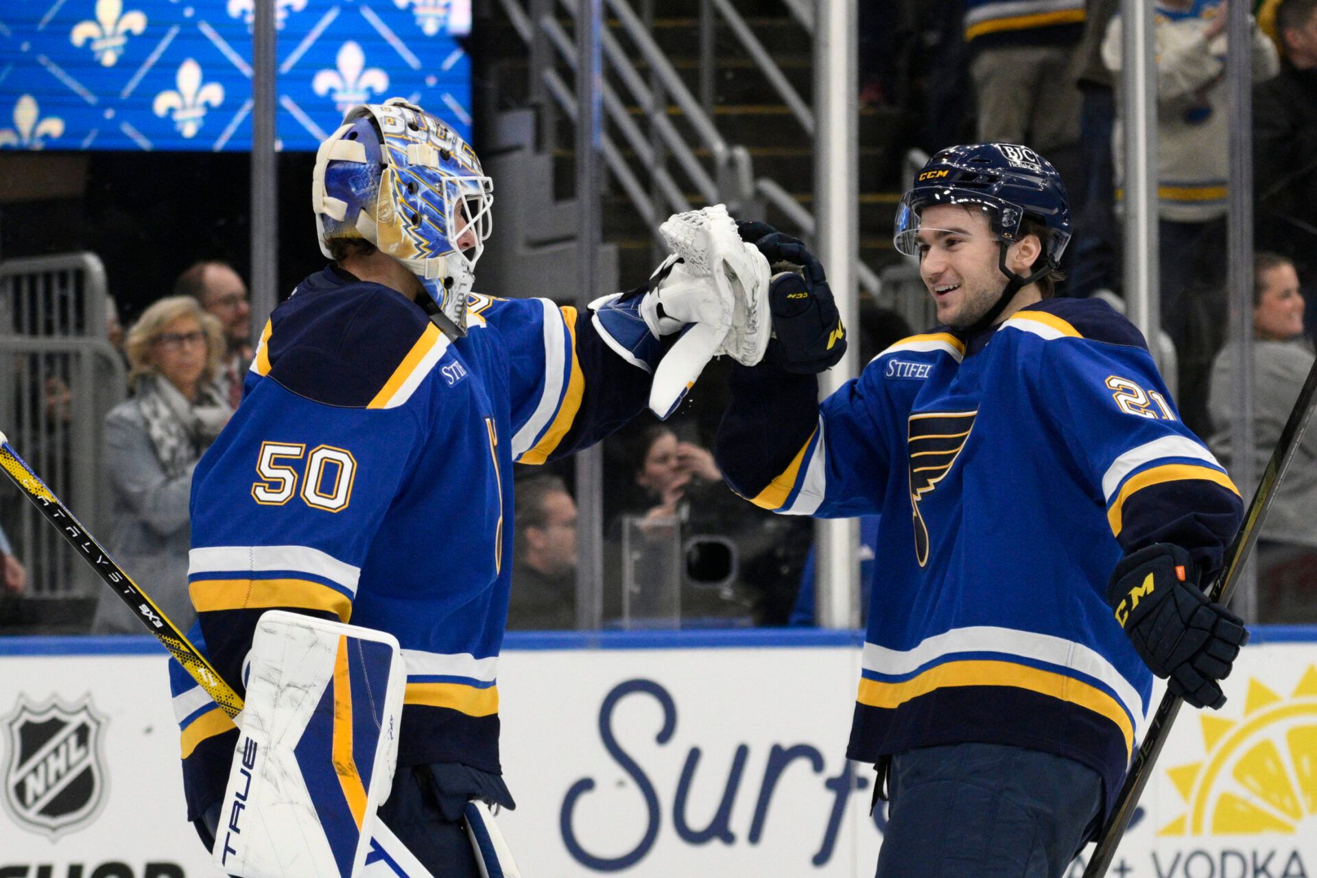 St. Louis Blues right wing Jimmy Snuggerud (21) and goaltender Jordan Binnington (50) celebrate a win against the Utah Hockey Club at Enterprise Center to clinch a spot in the playoffs.