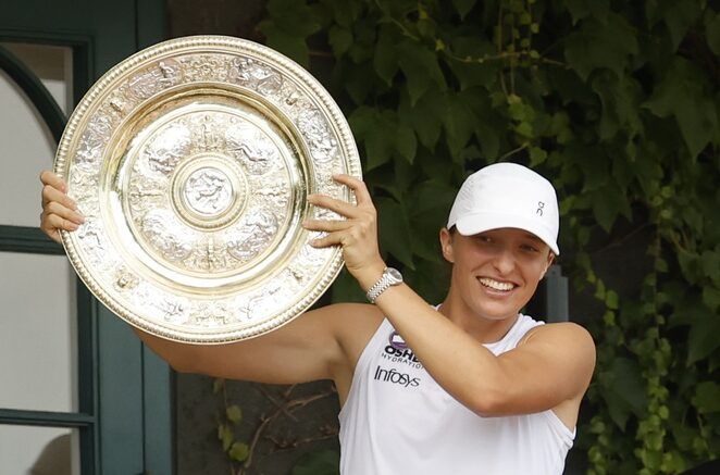 Iga Swiatek (POL) stands on the South West Hall balcony holding the Venus Rosewater Dish after her match against Amanda Anisimova (USA)(not pictured) in the ladies' singles championship on day thirteen of The Championships Wimbledon 2025 at All England Lawn Tennis and Croquet Club.