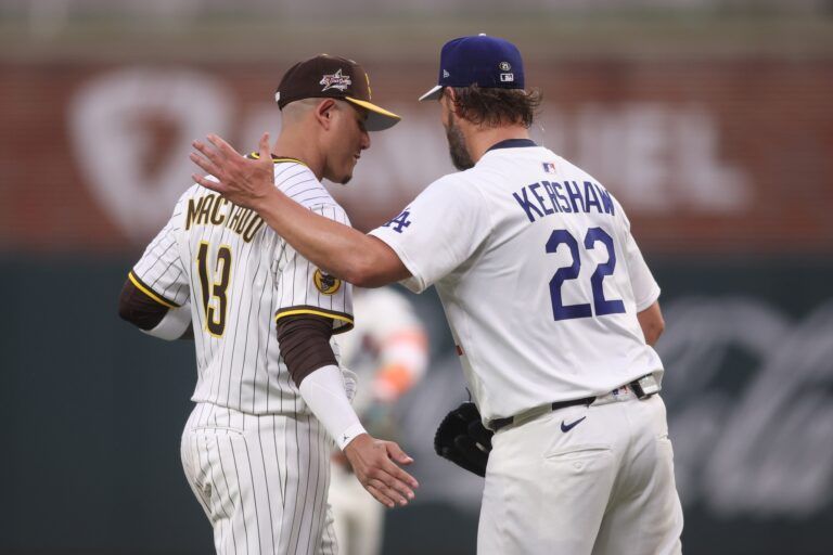 National League pitcher Clayton Kershaw (22) of the Los Angeles Dodgers reacts with third baseman Manny Machado (13) of the San Diego Padres in the second inning against the American League during the 2025 MLB All Star Game at Truist Park.