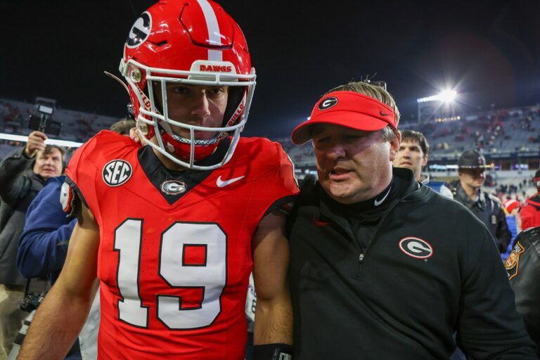 Georgia Bulldogs tight end Brock Bowers (19) and head coach Kirby Smart walk off the field after defeating the Georgia Tech Yellow Jackets at Bobby Dodd Stadium at Hyundai Field.