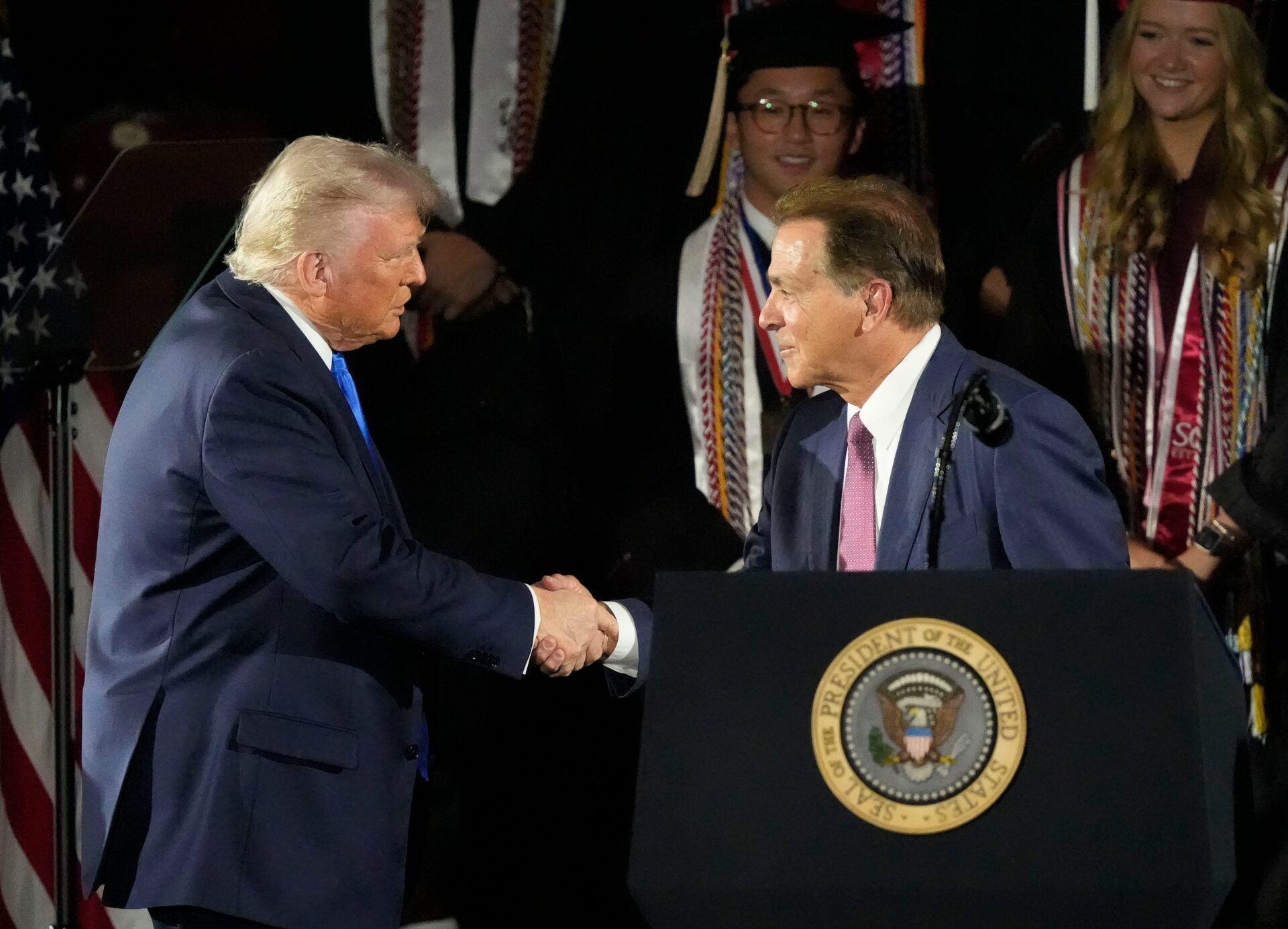 President Donald Trump shakes hands with legendary Alabama football coach Nick Saban before delivering a special commencement address to University of Alabama graduates at Coleman Coliseum on May 1, 2025. Graduation occurs over the weekend.