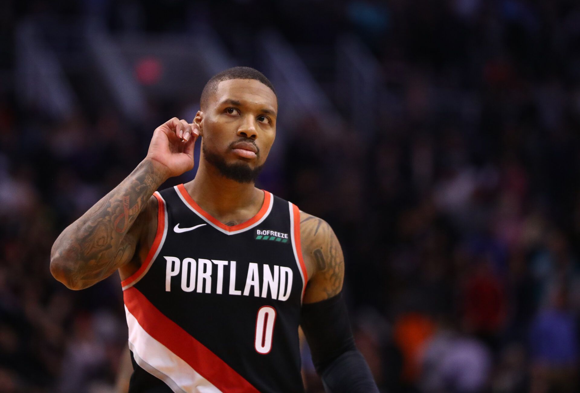 Portland Trail Blazers guard Damian Lillard puts his finger to his ear as he taunts the crowd after defeating the Phoenix Suns in the second half at Talking Stick Resort Arena.
