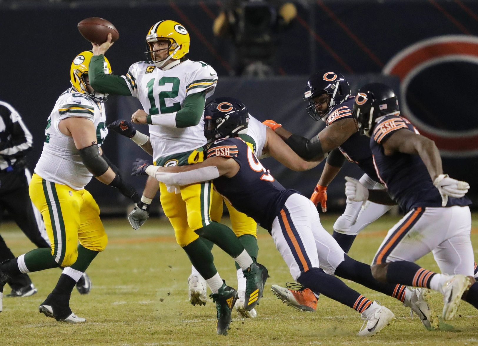 Green Bay Packers quarterback Aaron Rodgers (12) passes the ball under pressure from Chicago Bears linebacker Trevis Gipson (99) during their game on January 3, 2021, at Soldier Field in Chicago, Ill.