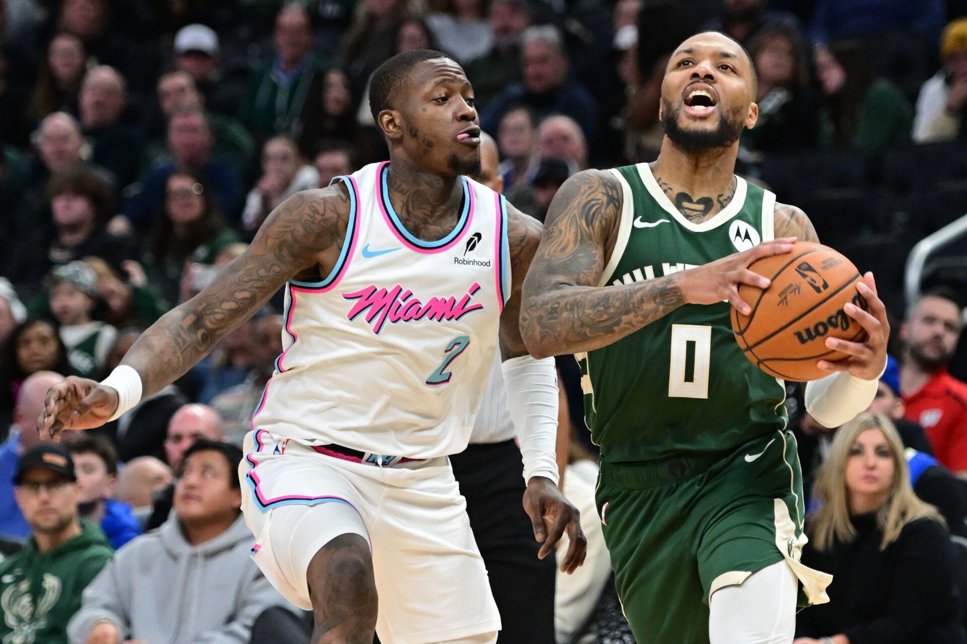 Milwaukee Bucks guard Damian Lillard (0) drives for the basket against Miami Heat guard Terry Rozier (2) in th fourth quarter at Fiserv Forum.
