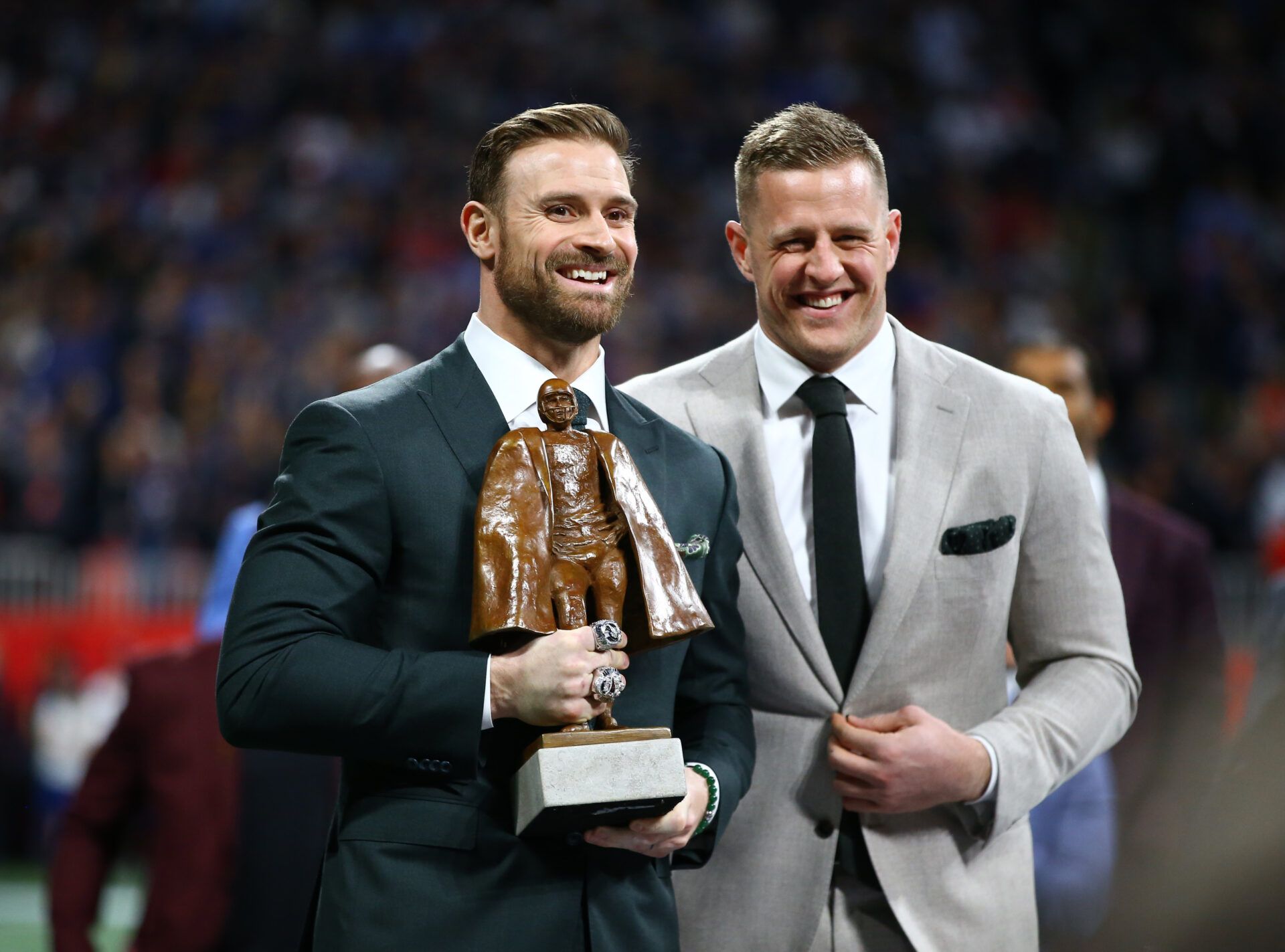 Houston Texans player J.J. Watt (right) presents the Walter Payton Man of the Year trophy to Philadelphia Eagles player Chris Long before Super Bowl LIII between the New England Patriots and the Los Angeles Rams at Mercedes-Benz Stadium.