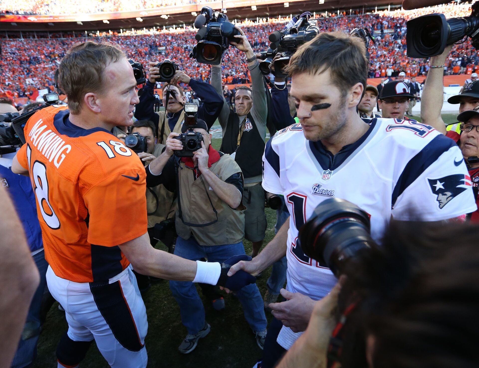 Denver Broncos quarterback Peyton Manning (18) meets with New England Patriots quarterback Tom Brady (12) after the 2013 AFC Championship game at Sports Authority Field at Mile High.