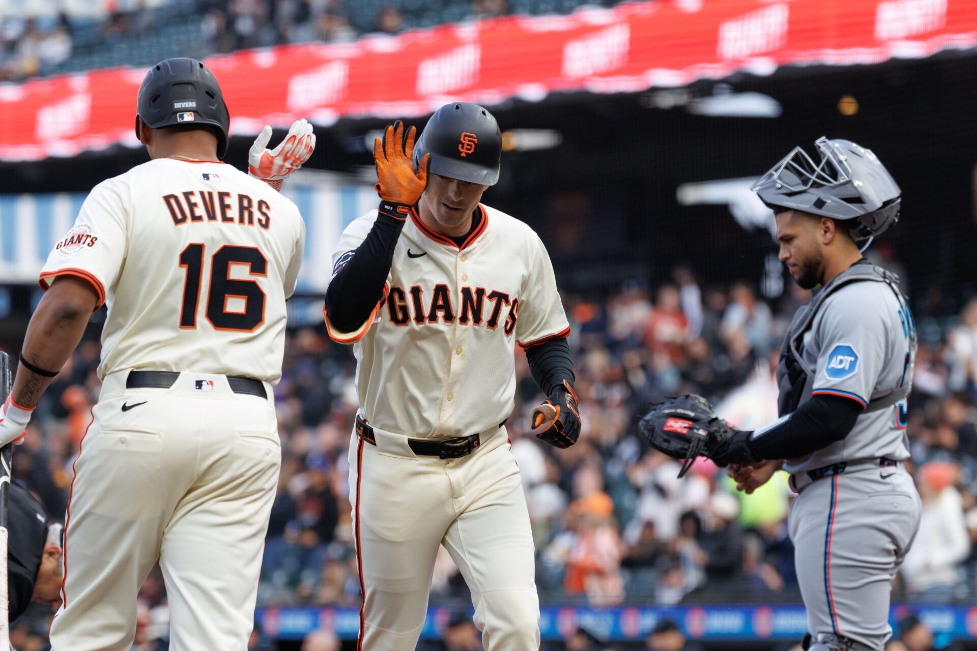 San Francisco Giants right fielder Mike Yastrzemski (5) shakes hands with designated hitter Rafael Devers (16) after hitting a one run home run during the first inning against the Miami Marlins at Oracle Park.