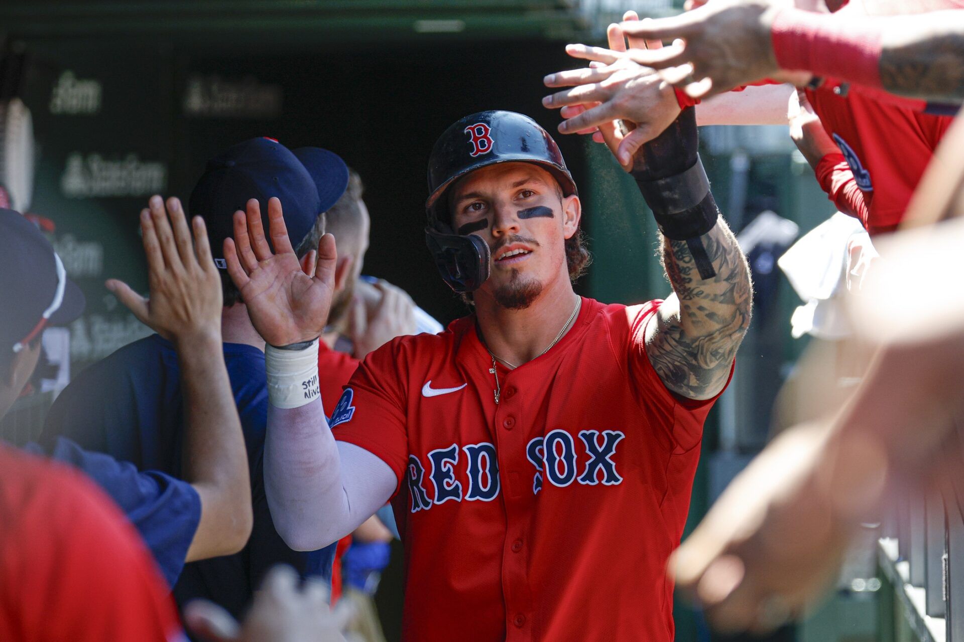 Boston Red Sox left fielder Jarren Duran (16) celebrates with teammates in the dugout after scoring against the Chicago Cubs during the third inning at Wrigley Field.