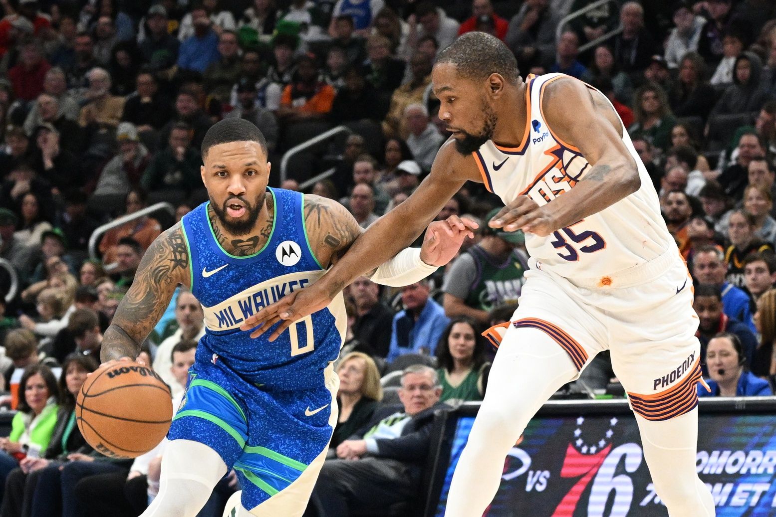 Milwaukee Bucks guard Damian Lillard (0) drives to the basket against Phoenix Suns forward Kevin Durant (35)  at Fiserv Forum.