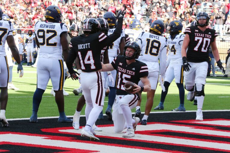 Texas Tech Red Raiders quarterback Will Hammond (15) celebrates with wide receiver Drew Hocutt (14) after scoring a touchdown against the West Virginia Mountaineers in the second half at Jones AT&T Stadium and Cody Campbell Field.