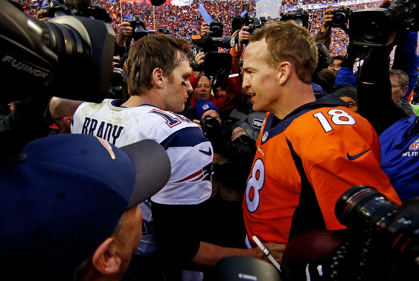 New England Patriots quarterback Tom Brady (12) and Denver Broncos quarterback Peyton Manning (18) shake hands and speak after the game in the AFC Championship football game at Sports Authority Field at Mile High.