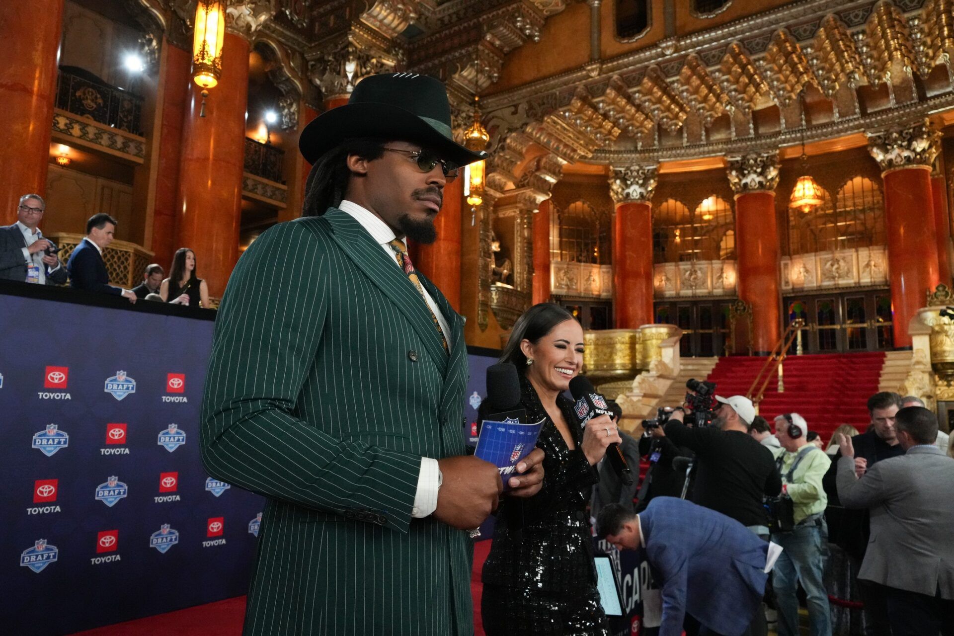 Former NFL quarterback Cam Newton and broadcaster Kaylee Hartung stand on the red carpet ahead of the 2024 NFL Draft at Detroit’s Fox Theatre.