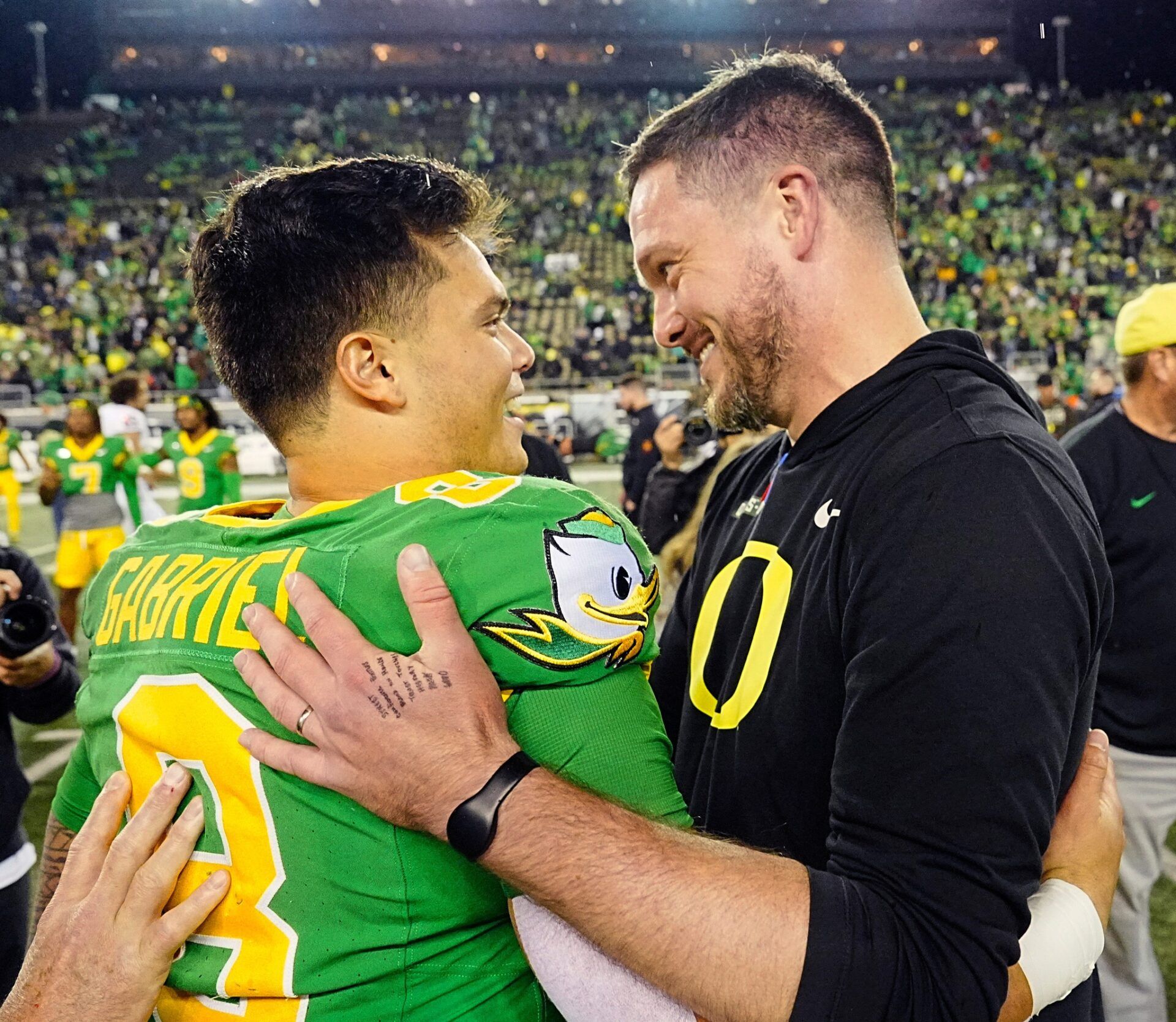 Oregon quarterback Dillon Gabriel, left, and coach Dan Lanning embrace after defeating Maryland at Autzen Stadium.