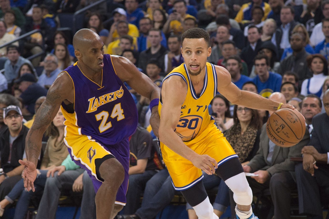 Golden State Warriors guard Stephen Curry (30) dribbles the basketball against Los Angeles Lakers forward Kobe Bryant (24) during the third quarter at Oracle Arena. The Warriors defeated the Lakers 111-77.