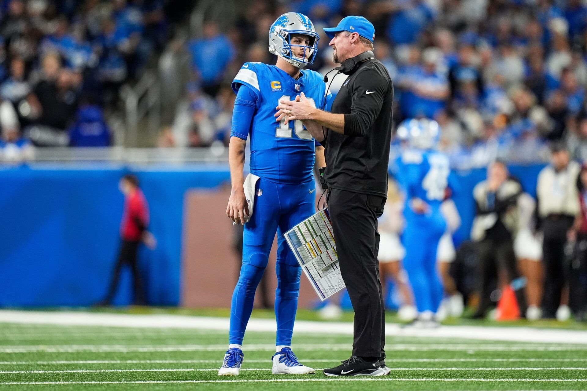 Detroit Lions quarterback Jared Goff (16) talks to head coach Dan Campbell before a play against Green Bay Packers during the second half at Ford Field in Detroit on Thursday, Dec. 5, 2024.