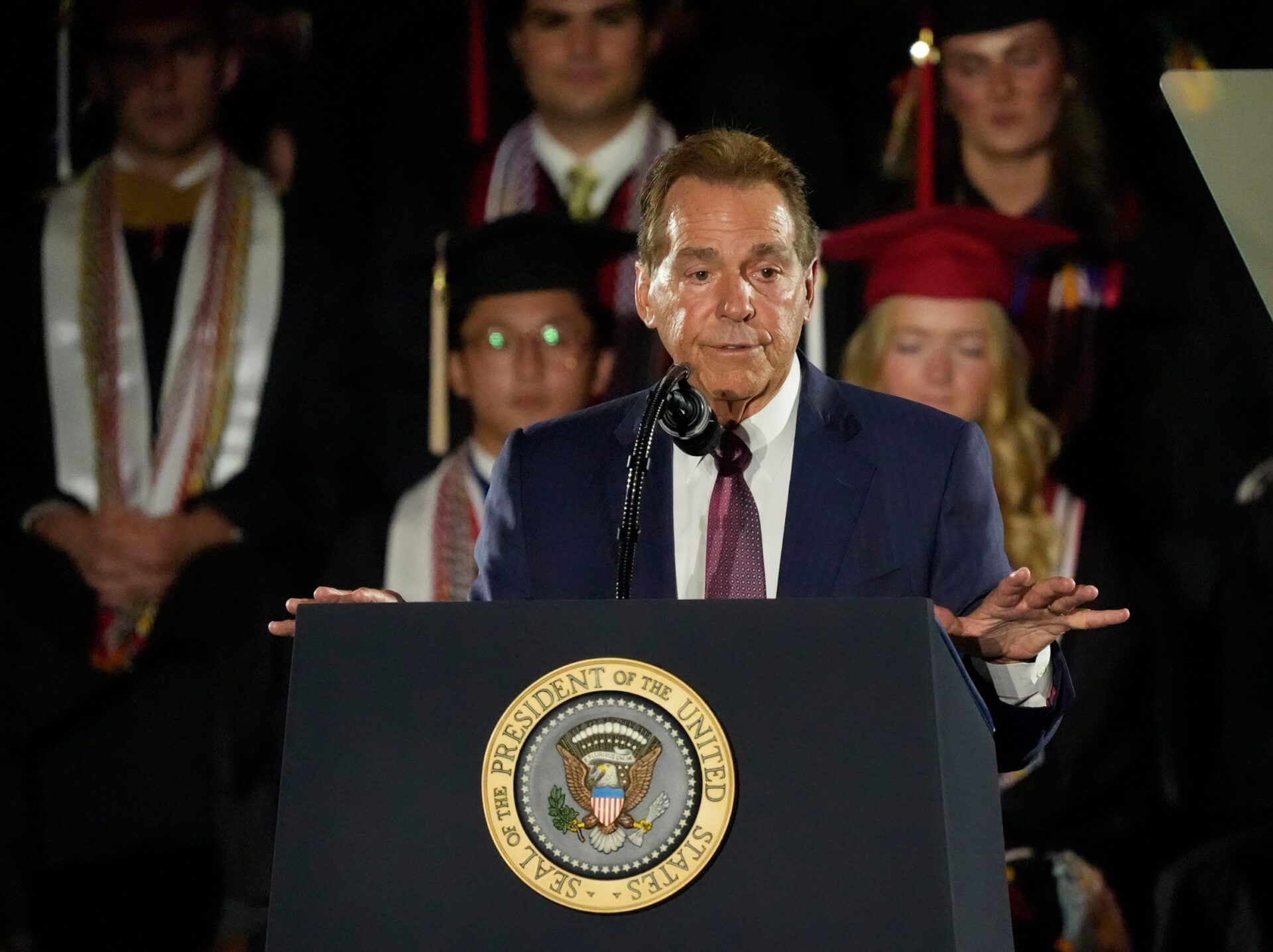Former Alabama football coach Nick Saban introduces President Donald Trump before a commencement address to University of Alabama graduates at Coleman Coliseum.