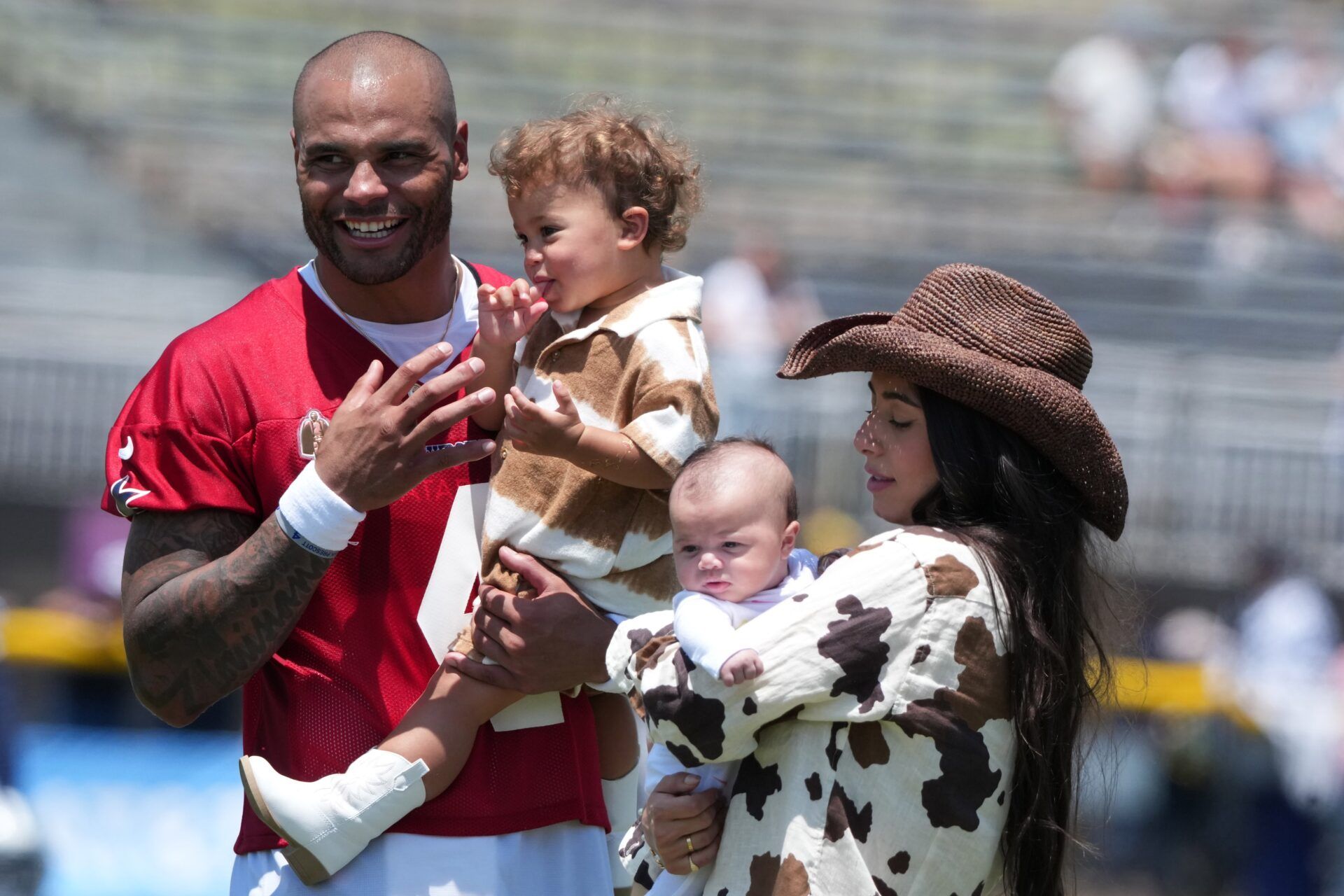 Dallas Cowboys quarterback Dak Prescott (4) visits with fiancee Sarah Jane Ramos and daughters MJ Rose Prescott (right) and Aurora Prescott (left) during training camp at the River Ridge Fields.