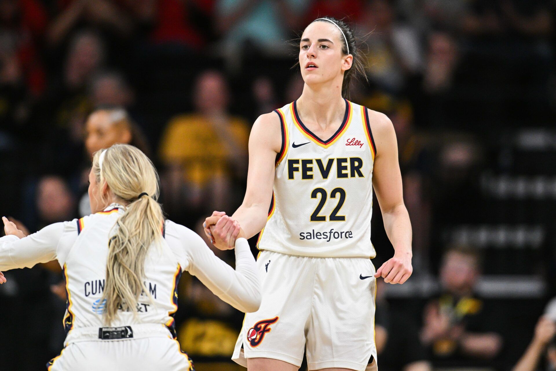 Indiana Fever guard Caitlin Clark (22) assists guard Sophie Cunningham (8) during the game against the Brazil National Team at Carver-Haweye Arena.