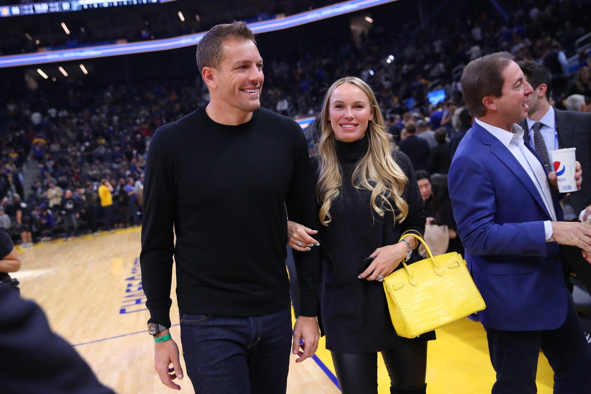 Former NBA player David Lee walks with his wife and professional tennis player Caroline Wozniacki at halftime during the Golden State Warriors and San Antonio Spurs game at the Chase Center.