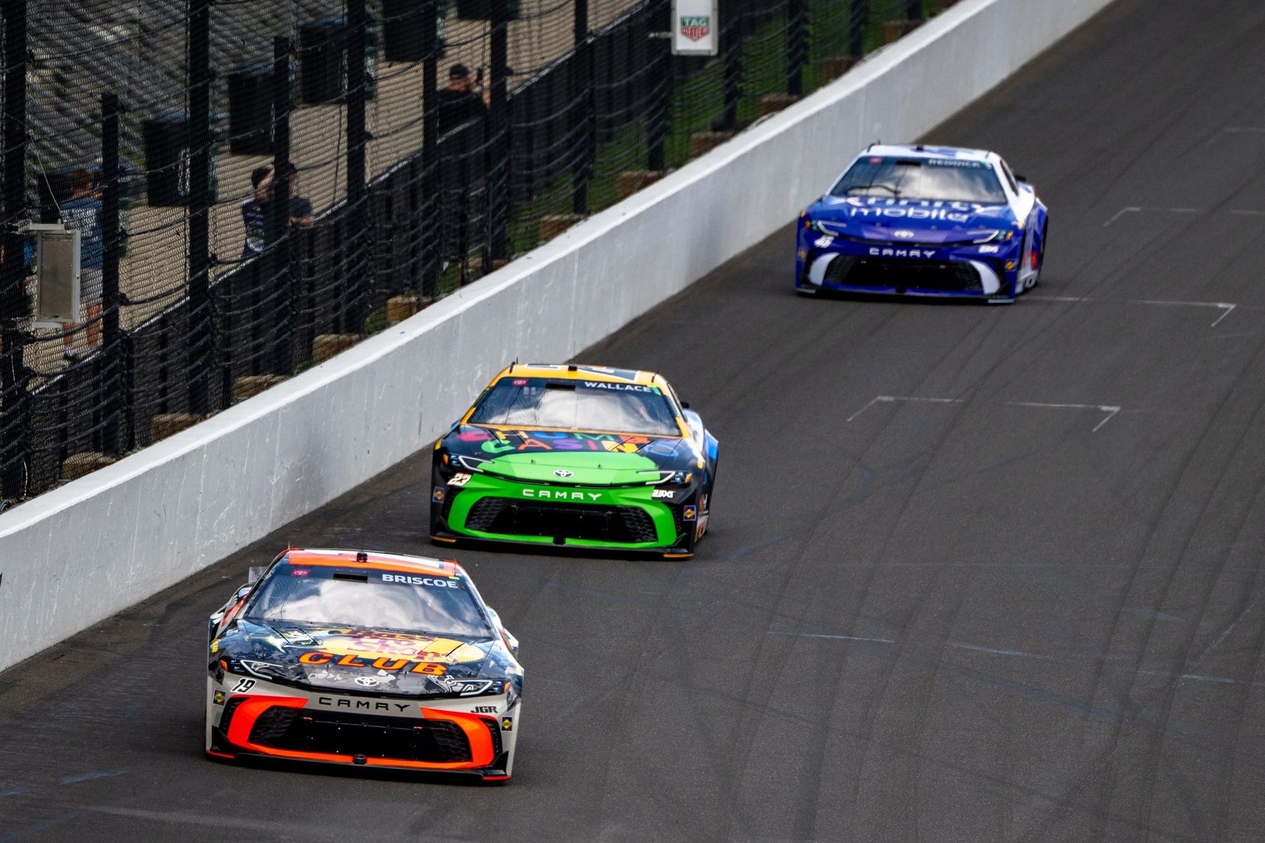 NASCAR Cup Series driver Chase Briscoe (19) leads Bubba Wallace (23) and Tyler Reddick (45) into the first turn Sunday, July 27, 2025, during the Brickyard 400 at Indianapolis Motor Speedway.