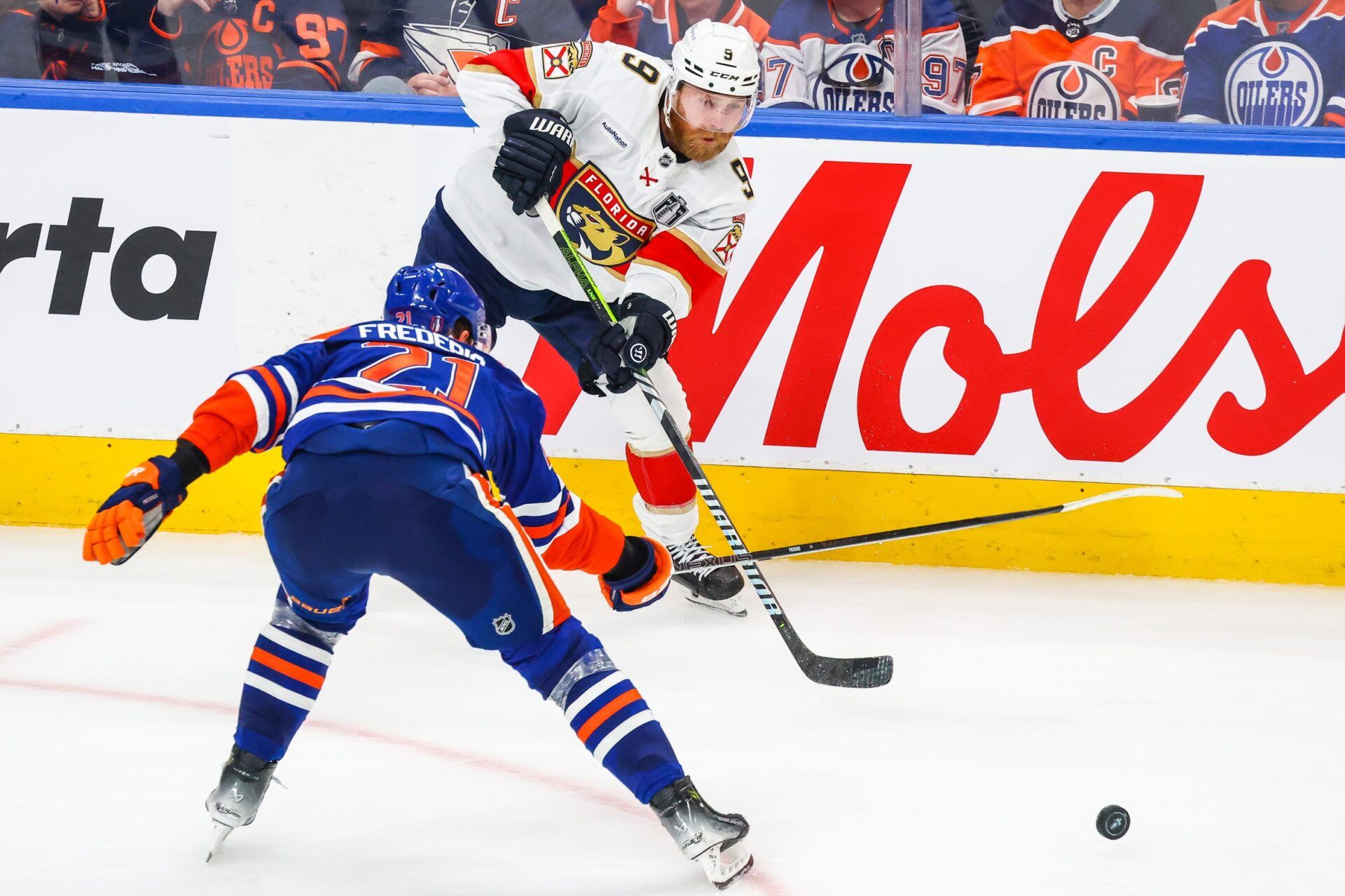 Florida Panthers center Sam Bennett (9) passes the puck against Edmonton Oilers center Trent Frederic (21) during the second period in game five of the 2025 Stanley Cup Final at Rogers Place.
