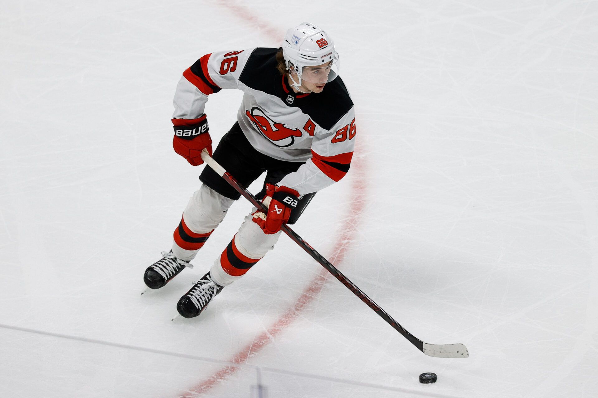 New Jersey Devils center Jack Hughes (86) controls the puck in the first period against the Colorado Avalanche at Ball Arena.