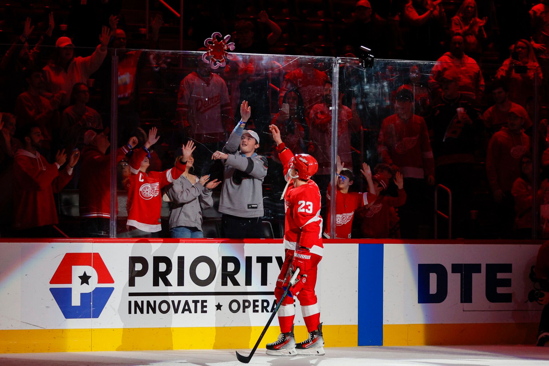 Detroit Red Wings left wing Lucas Raymond (23) tosses a stuffed octopus into the crowd following the team's win against the Dallas Stars at Little Caesars Arena.