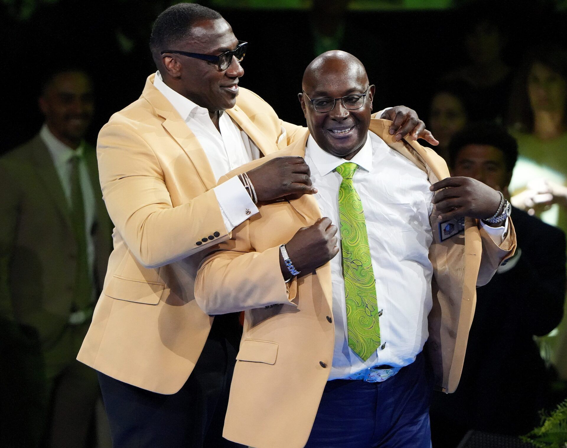 Class of 2025 new Hall of Famer Sterling Sharpe ,right,, is helped into his gold jacket by his presenter Class of 2011 Hall of Famer and his brother Shannon Sharpe ,at the Pro Football Hall of Fame Gold Jacket Dinner held at the Canton Memorial Civic Center Friday, August 1, 2025.