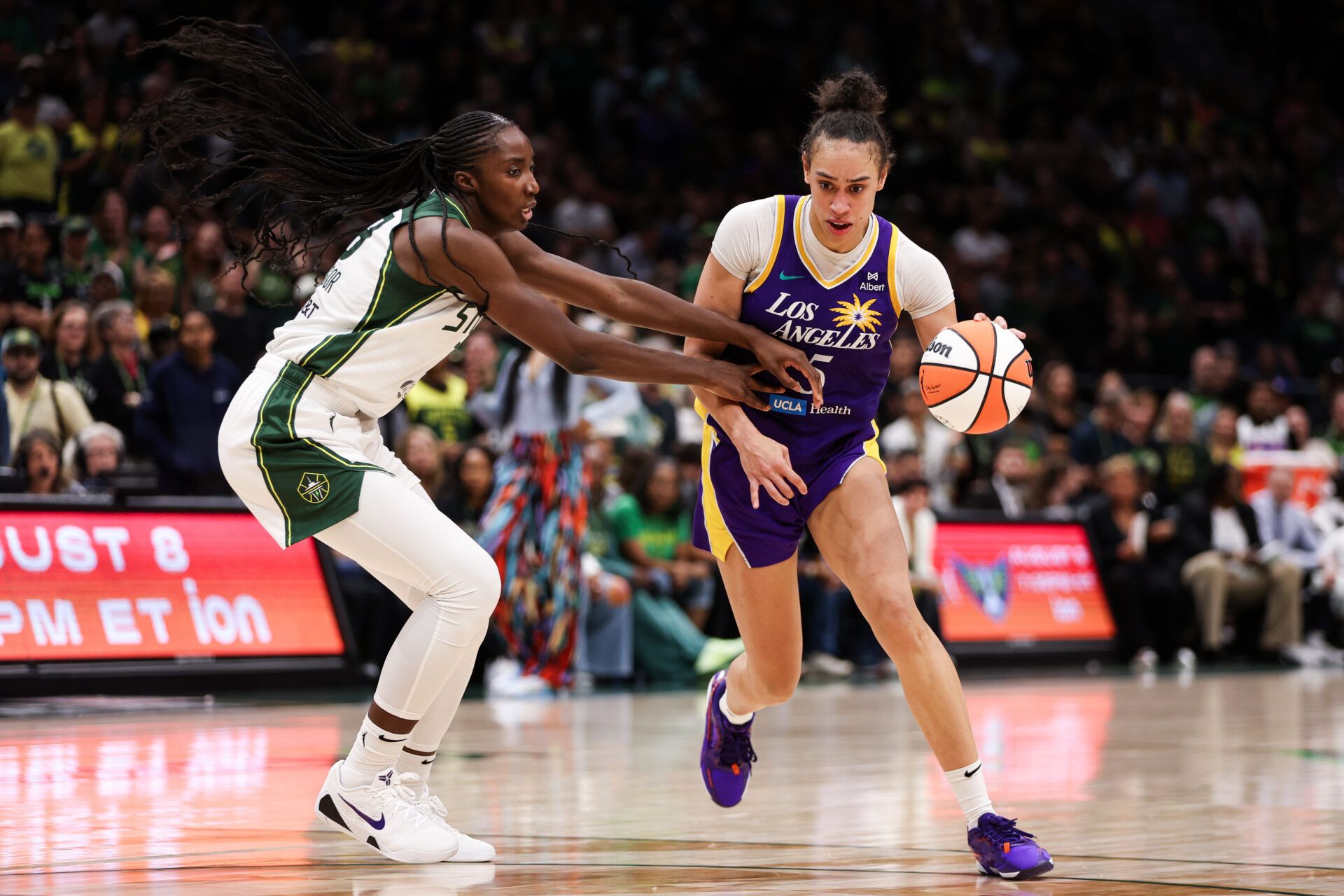 Los Angeles Sparks forward Dearica Hamby (5) drives the ball past Seattle Storm forward Ezi Magbegor (13) during overtime at Climate Pledge Arena.