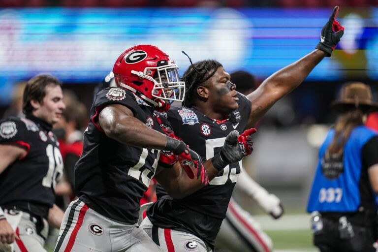 Georgia Bulldogs linebacker Azeez Ojulari (13) reacts with offensive lineman Broderick Jones (59) after he sacked Cincinnati Bearcats quarterback Desmond Ridder (9) (not shown) for a safety on the games final play during the second half at Mercedes-Benz Stadium.