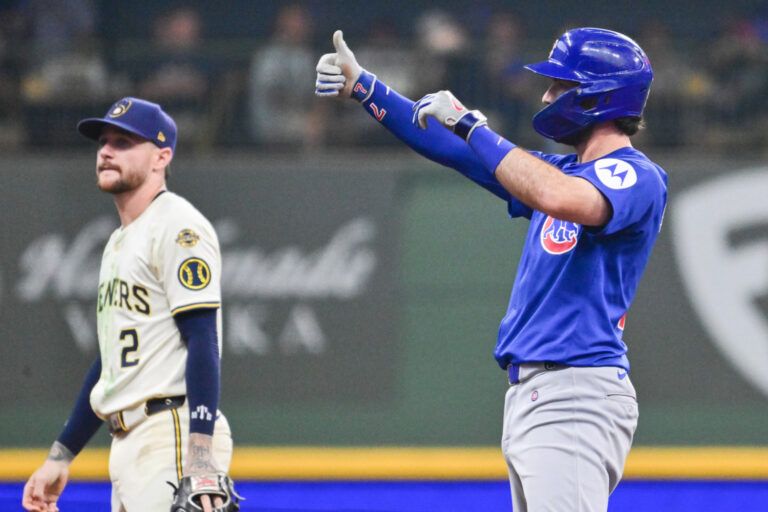 Chicago Cubs shortstop Dansby Swanson (7) reacts after hitting a double to drive in a run in the sixth inning as Milwaukee Brewers second baseman Brice Turang (2) looks on at American Family Field.