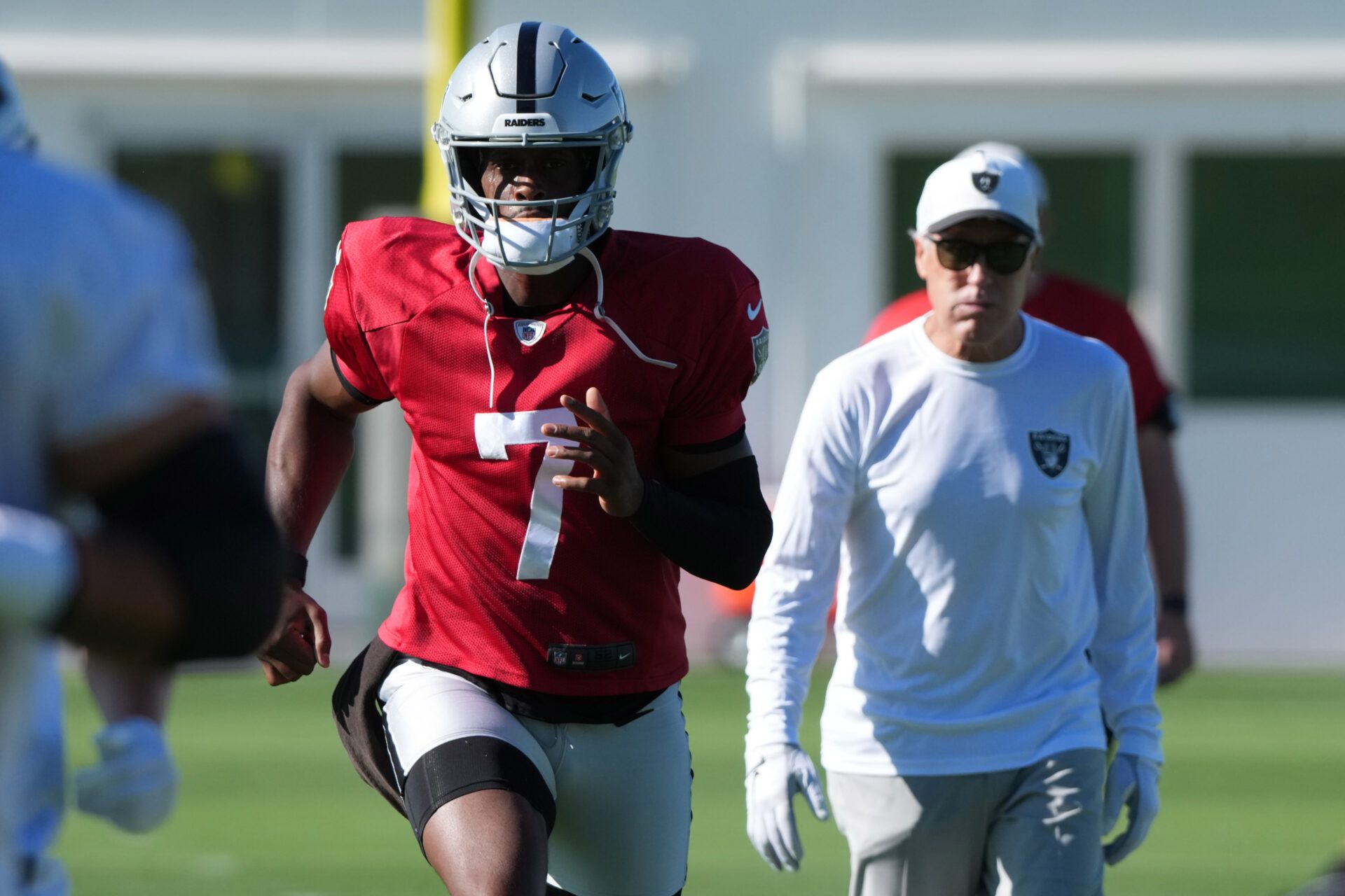 Las Vegas Raiders quarterback Geno Smith (7) with coach Pete Carroll during training camp at the Intermountain Healthcare Performance Center.