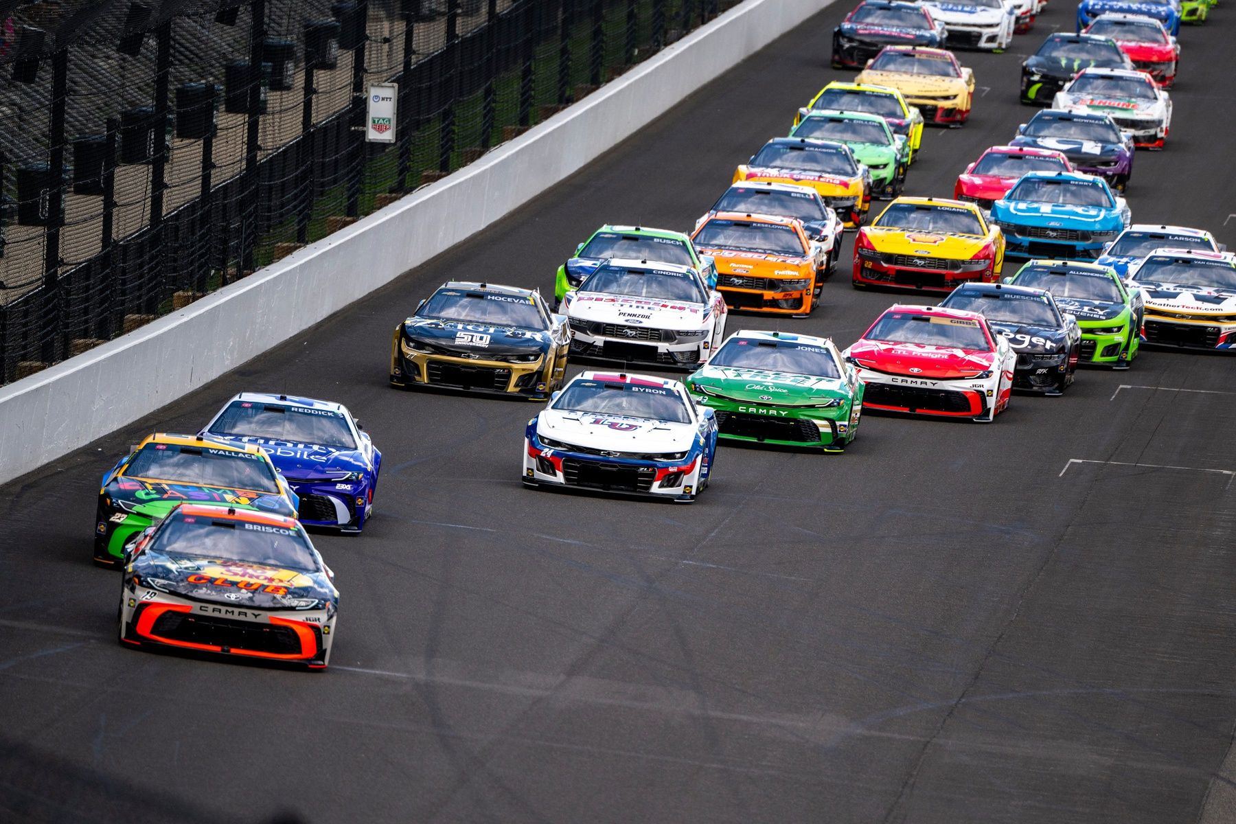 NASCAR Cup Series driver Chase Briscoe (19) leads the field of cars into the first turn Sunday, July 27, 2025, during the Brickyard 400 at Indianapolis Motor Speedway.