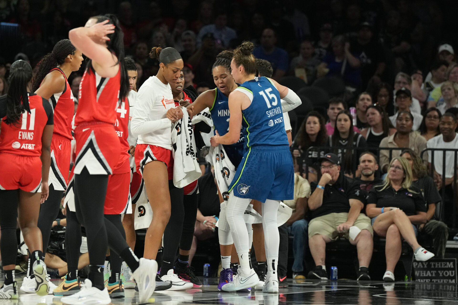 Players from the Las Vegas Aces and Minnesota Lynx surround Lynx forward Napheesa Collier (24) after she does down with an injury in the third quarter of their game at Michelob Ultra Arena.