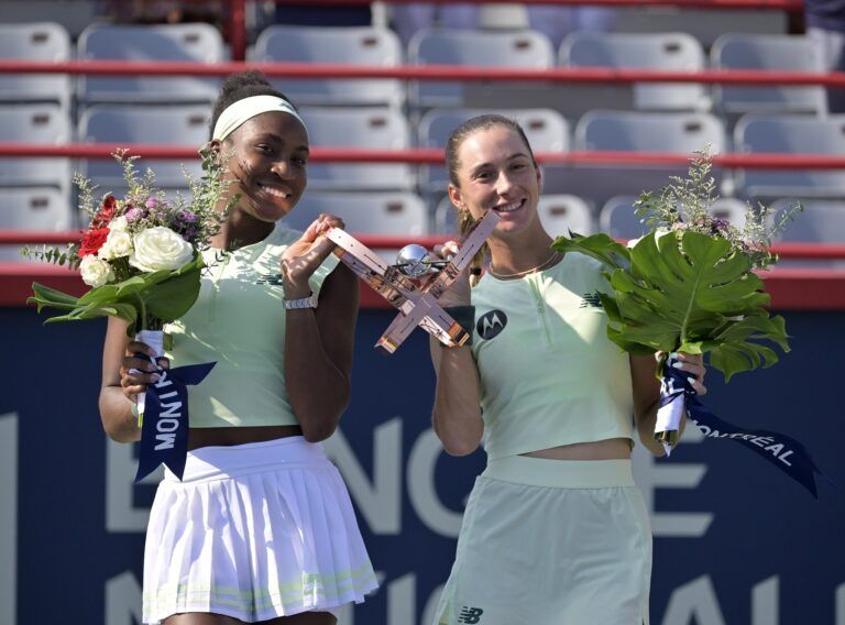 Coco Gauff (USA) and McCartney Kessler (USA) pose with the championship trophy after the doubles final at IGA Stadium.