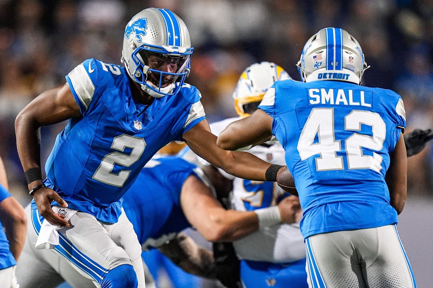Detroit Lions quarterback Hendon Hooker (2) hands the ball to running back Jabari Small (42) against LA Chargers during the second half of the Hall of Fame Game at Tom Benson Hall of Fame Stadium in Canton, Ohio on Thursday, July 31, 2025.