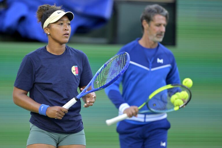 Naomi Osaka (JPN) practices on the first day of the BNP Paribas open as her coach Patrick Mouratoglou looks on at the Indian Well Tennis Garden.
