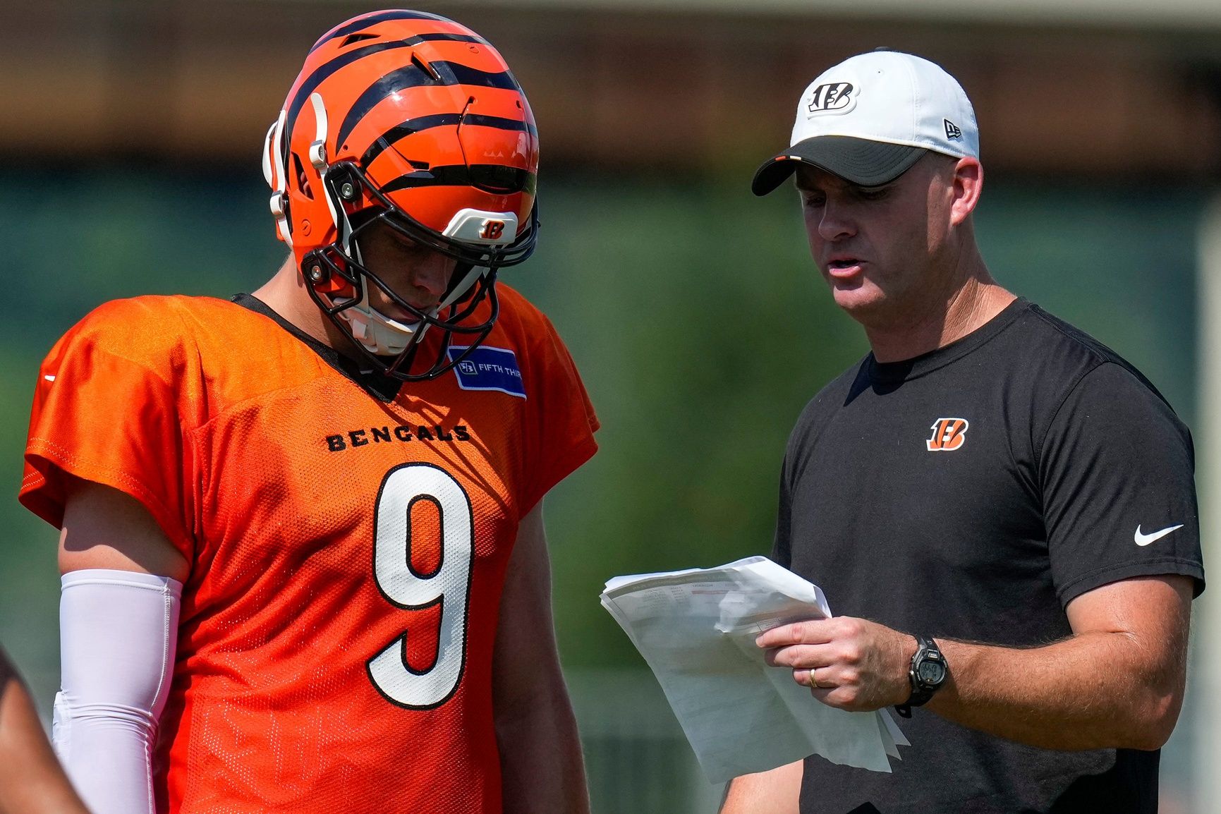Cincinnati Bengals quarterback Joe Burrow (9) talks with head coach Zac Taylor during a preseason training camp practice in downtown Cincinnati on Wednesday, July 30, 2025.