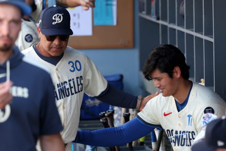 Los Angeles Dodgers two-way player Shohei Ohtani (17) is greeted in the dugout by manager Dave Roberts (30) after pitching against the Houston Astros in the second inning at Dodger Stadium.