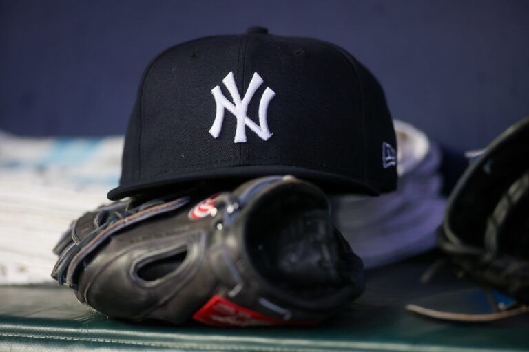 A detailed view of a New York Yankees hat and glove on the bench against the Atlanta Braves in the third inning at Truist Park.