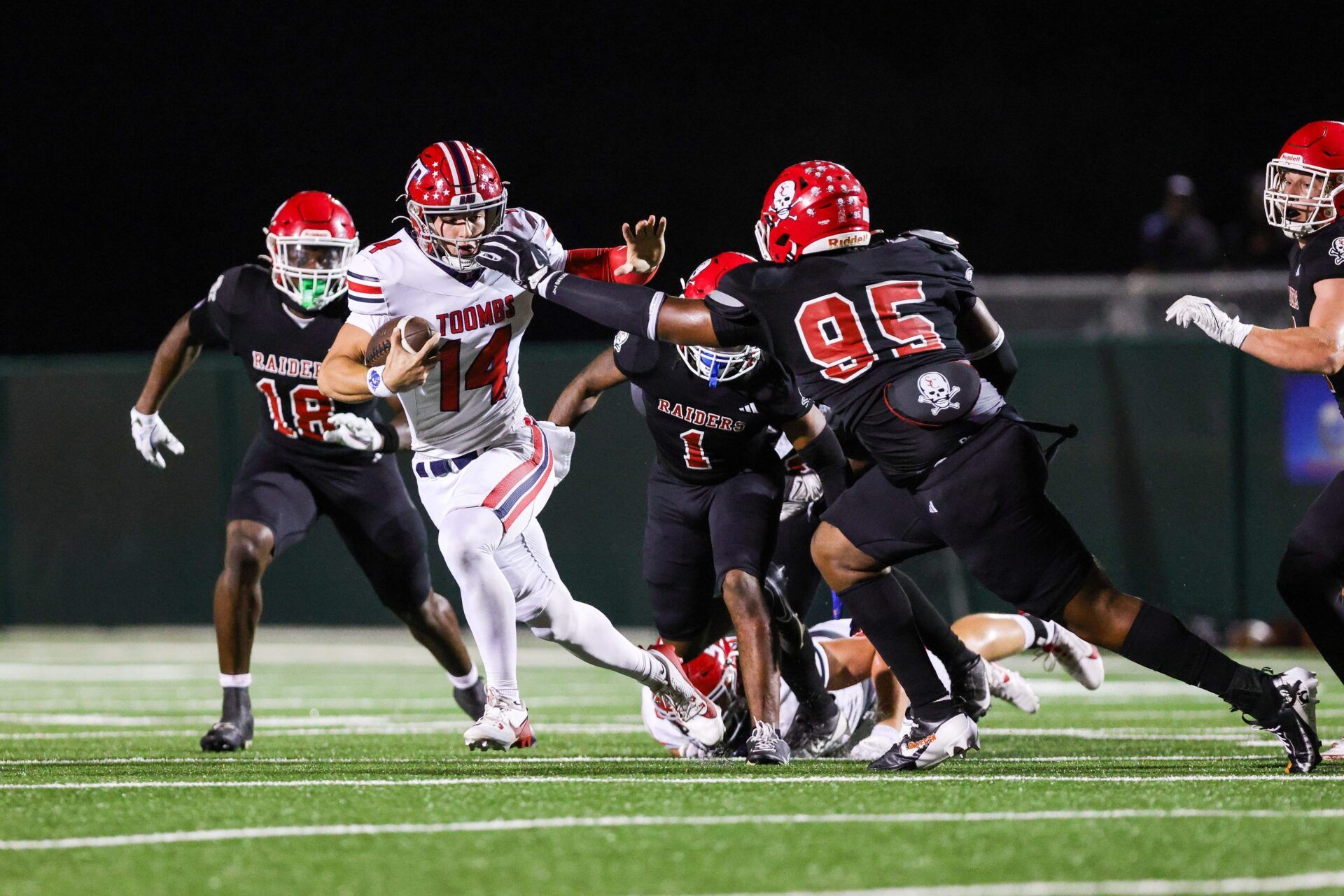Toombs Quarterback TJ Stanley (14) attempts to break away from Savannah Christian's Elijah Griffin (No. 95) while his Raider teammate LaDamion Guyton (N0. 18) pursues Stanley from behind in a game at Pooler Stadium on Nov. 1, 2024.