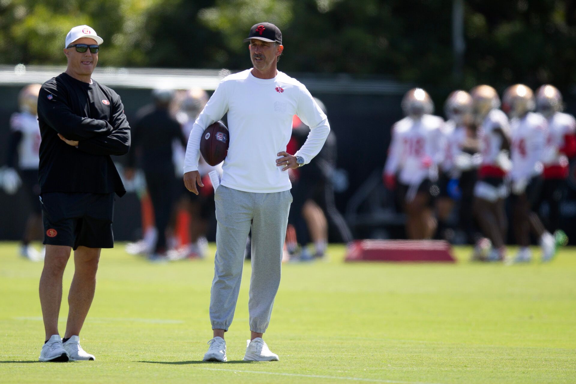 San Francisco 49ers head coach Kyle Shanahan (right) watches his players work out during a team OTA at Levi's Stadium.