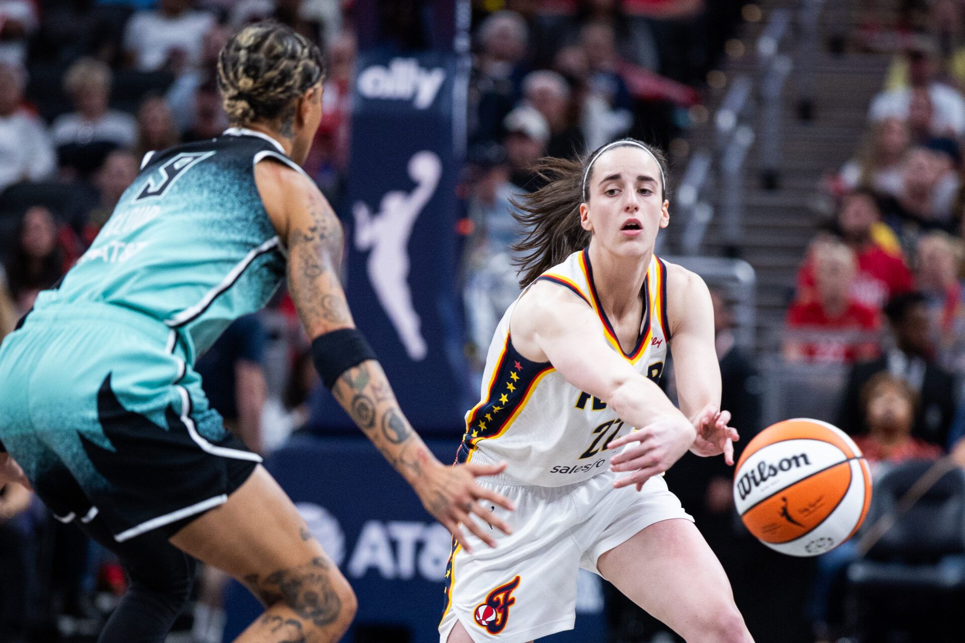 Indiana Fever guard Caitlin Clark (22) passes the ball while New York Liberty guard Natasha Cloud (9) defends in the second half at Gainbridge Fieldhouse.