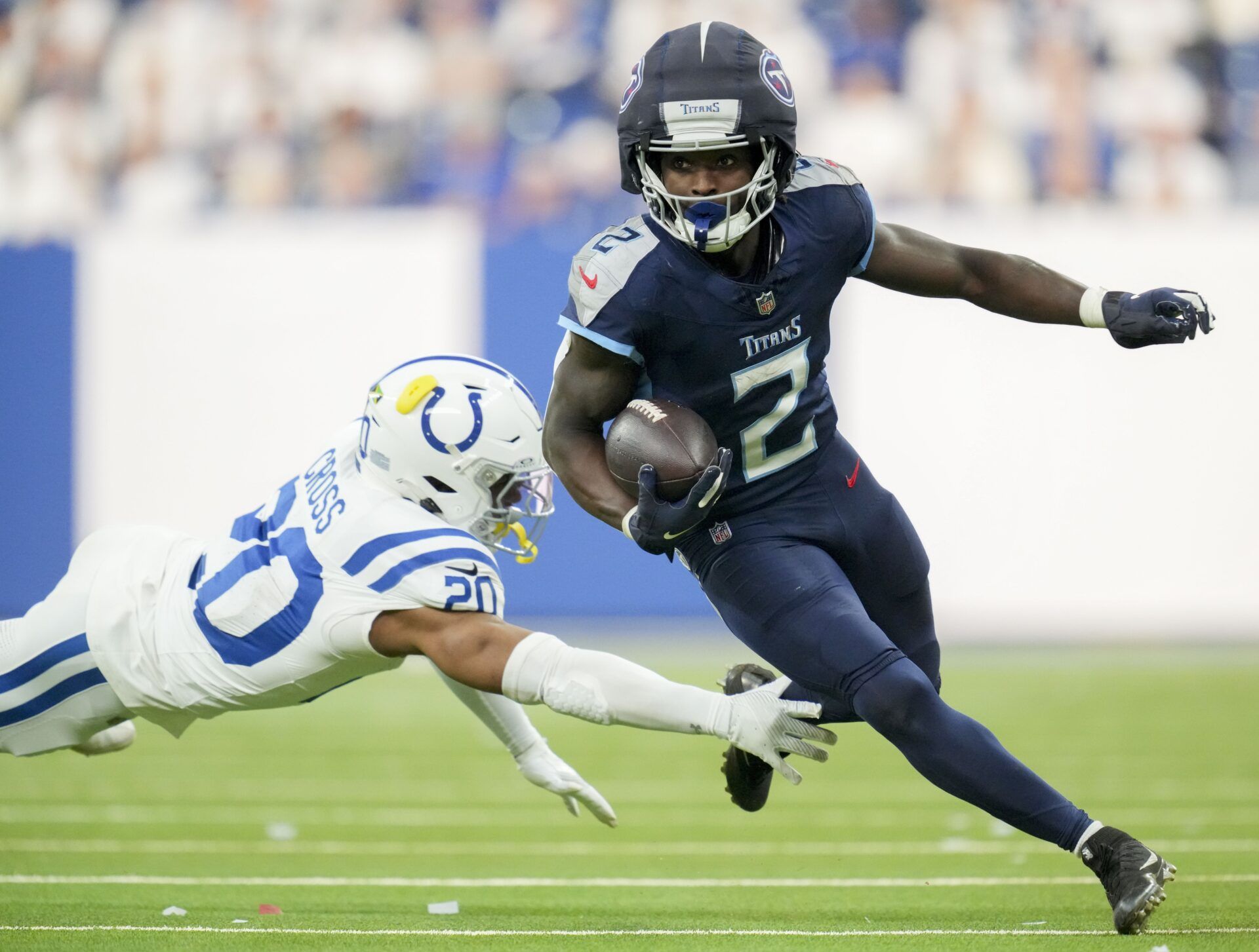 Indianapolis Colts safety Nick Cross (20) dives after Tennessee Titans running back Tyjae Spears (2) during a game against the Tennessee Titans at Lucas Oil Stadium.