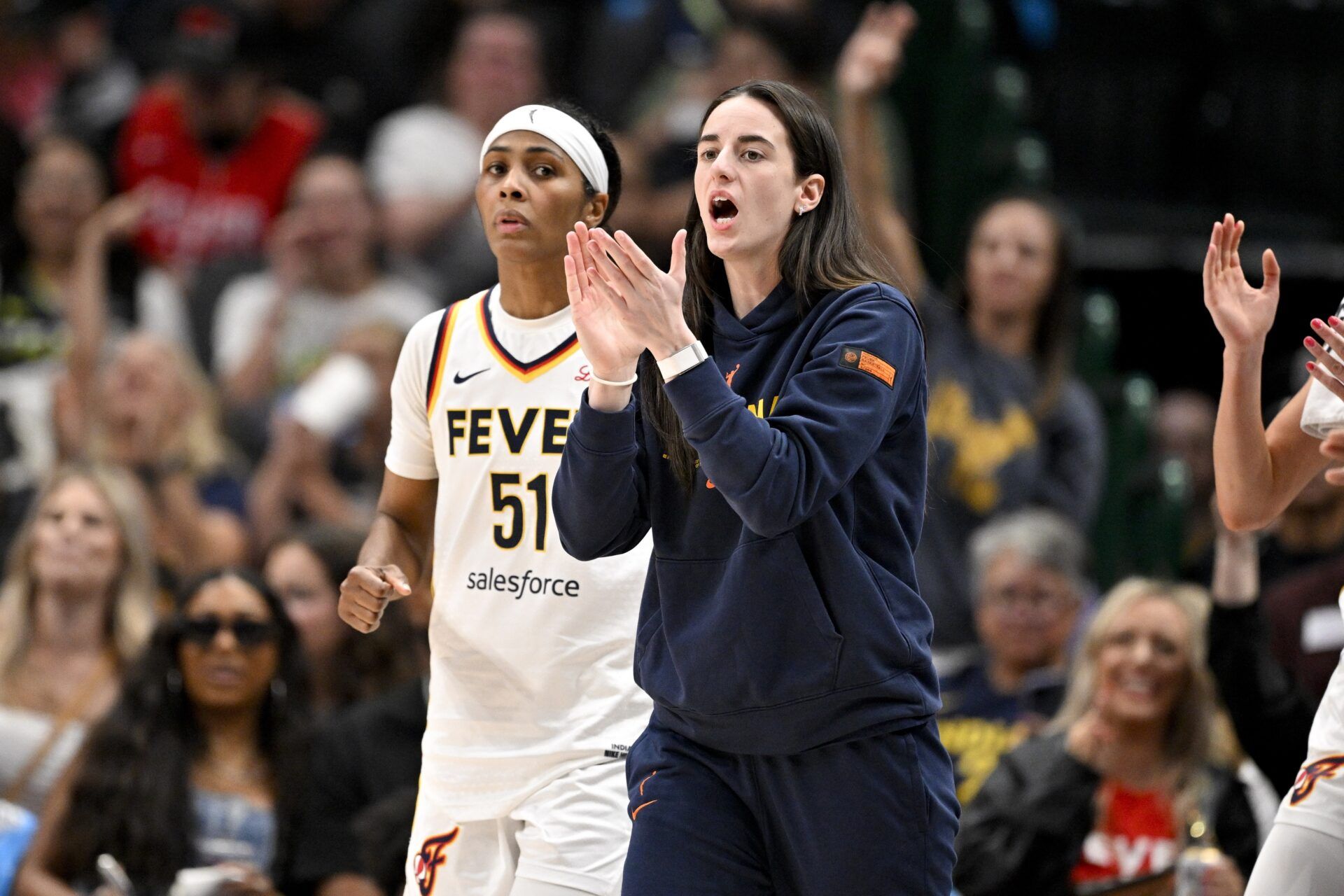 Indiana Fever guard Sydney Colson (51) and guard Caitlin Clark (22) cheer for their team during the first half against the Dallas Wings at the American Airlines Center.