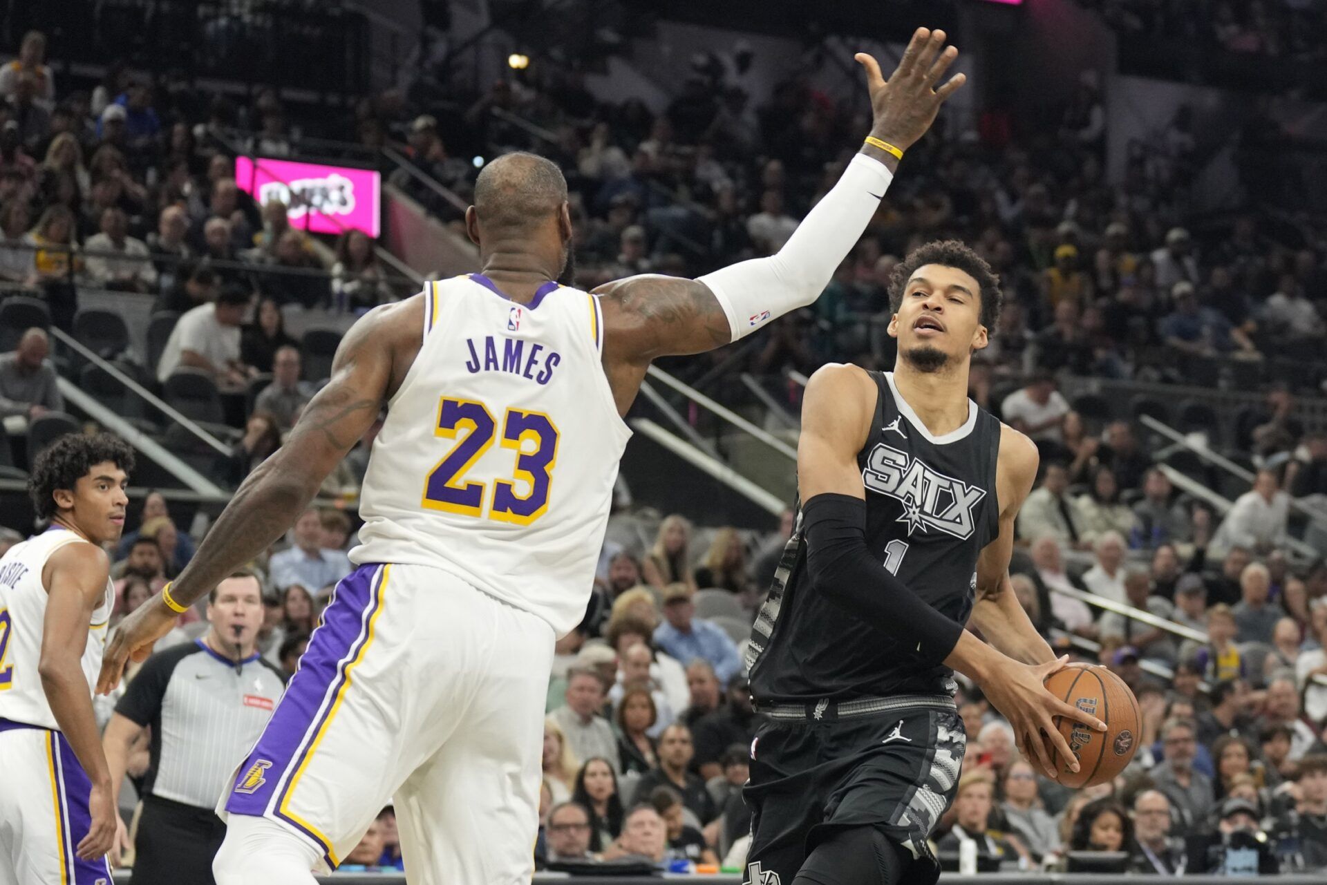 San Antonio Spurs center Victor Wembanyama (1) drives to the basket past Los Angeles Lakers forward LeBron James (23) during the first half at Frost Bank Center.