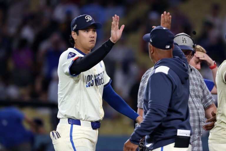 Los Angeles Dodgers designated hitter Shohei Ohtani (17) celebrates a win with manager Dave Roberts (30, right) after defeating the Toronto Blue Jays 9-1 at Dodger Stadium.