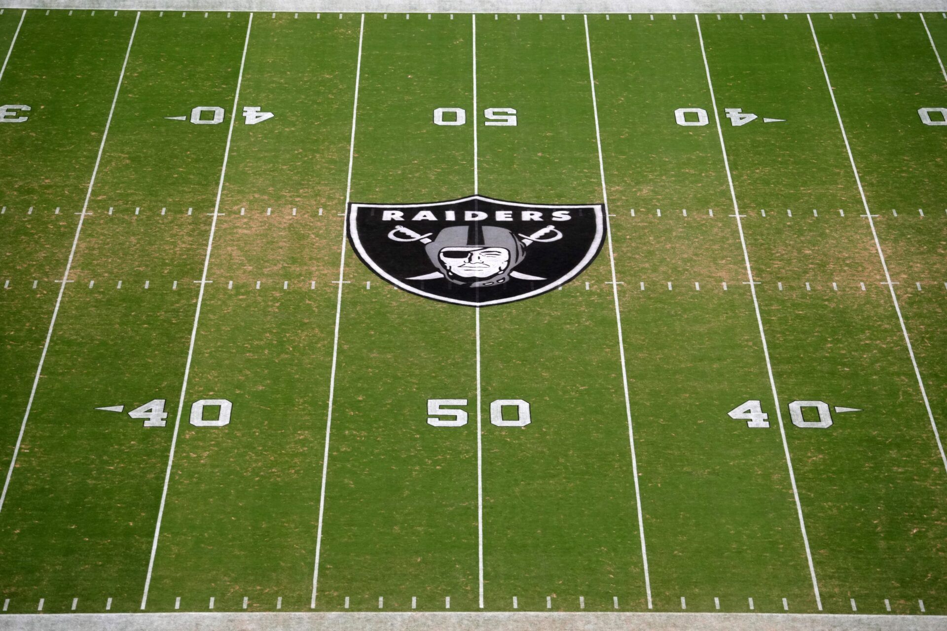 The Las Vegas Raiders shield logo at midfield at Allegiant Stadium.