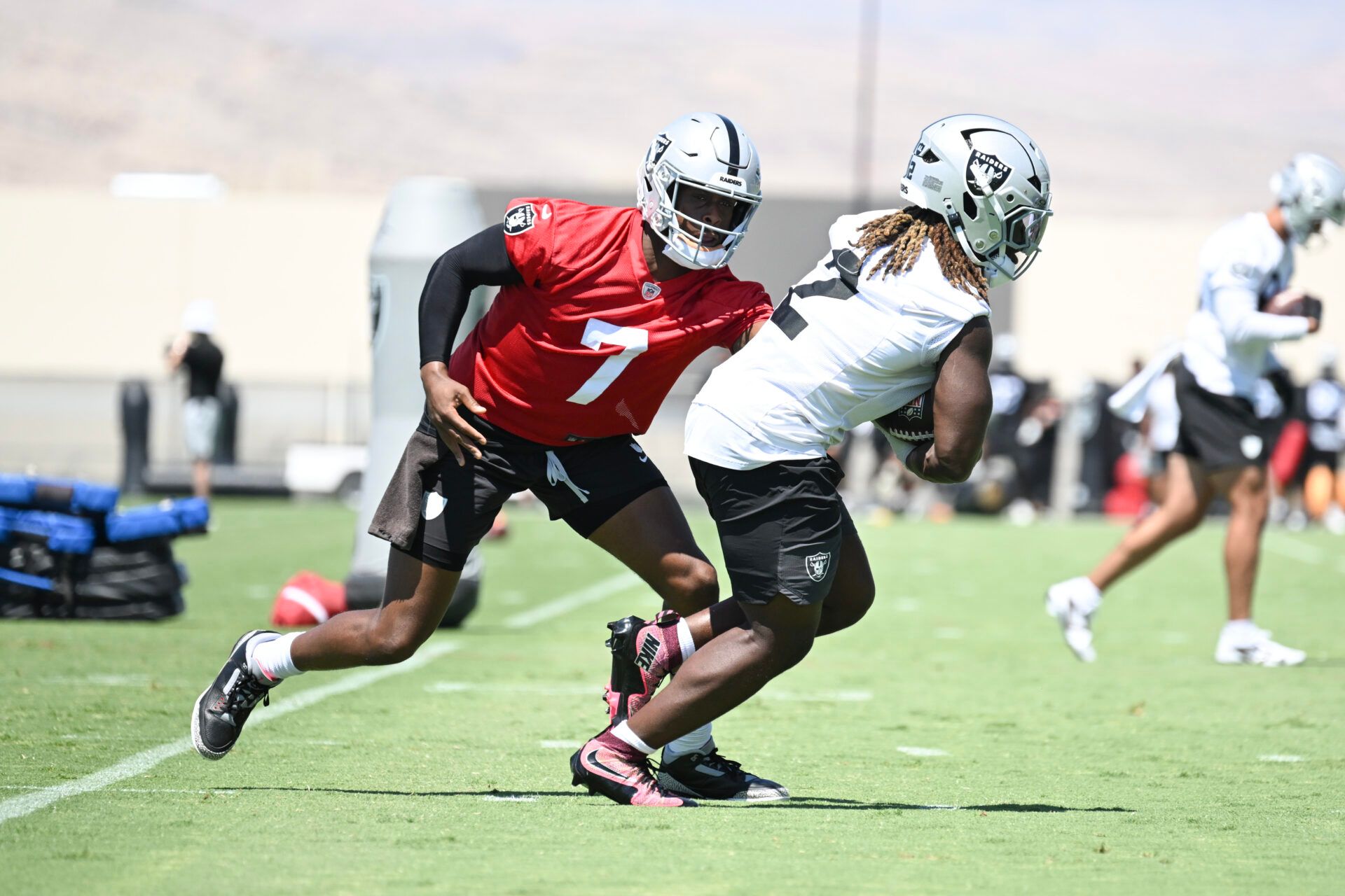 Las Vegas Raiders quarterback Geno Smith (7) hands the ball to running back Ashton Jeanty (2) during Las Vegas Raiders Minicamp at Intermountain Health Performance Center.