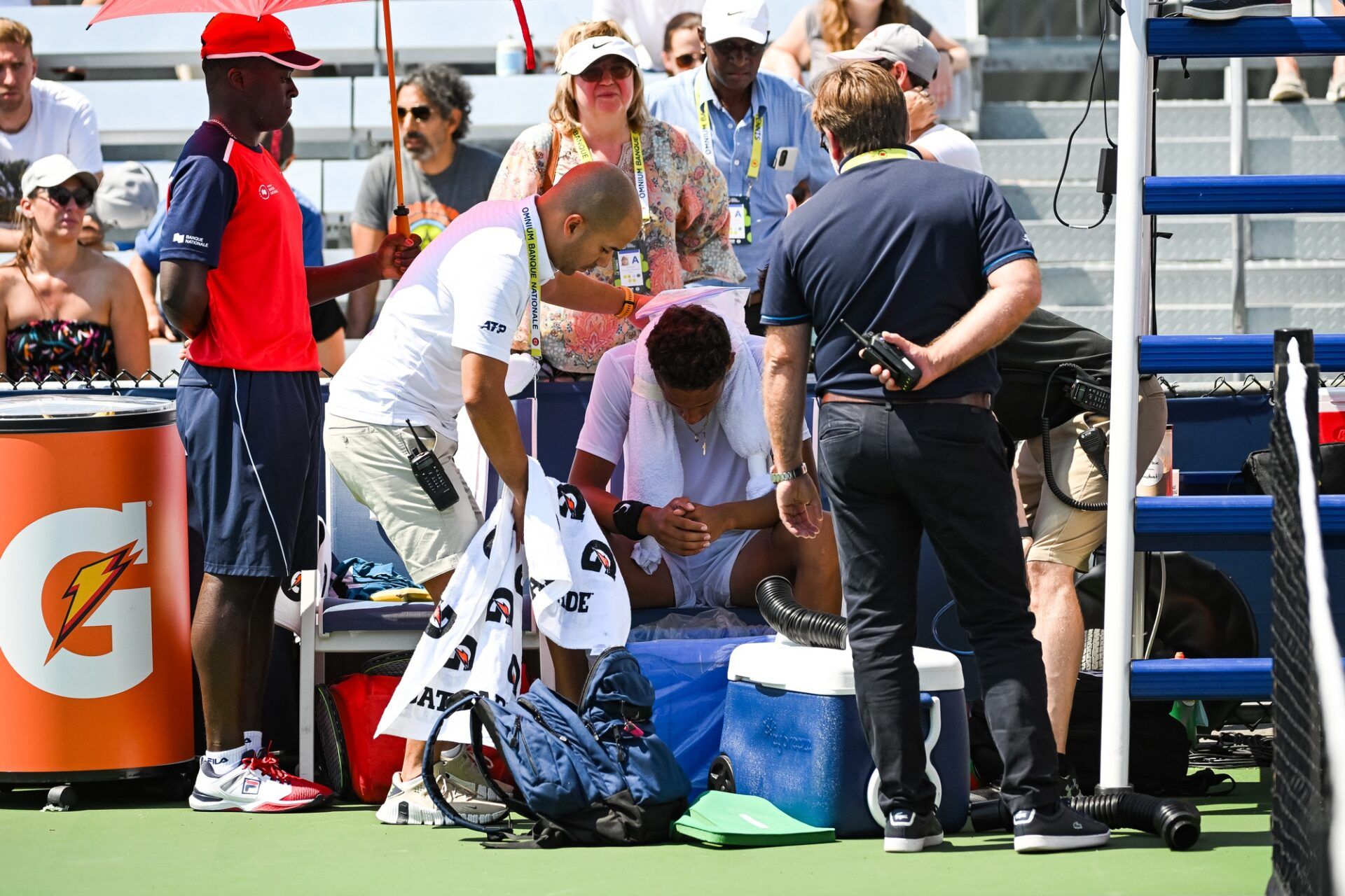 Gabriel Diallo (CAN) suffers a heat atroke against Hugo Gaston (FRA) (not pictured)  in second round qualifying play at IGA Stadium.